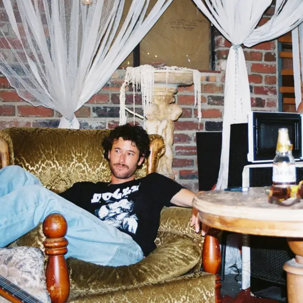 Tom Cribb sitting on a gold velvet couch